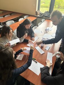 studenci z papieru robią zamek w ramach pracy w zespole