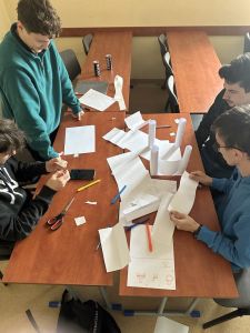 studenci z papieru robią zamek w ramach pracy w zespole